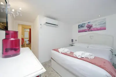 a white room with a bed and a table with towels at 4BNB - Domus Colosseo in Rome
