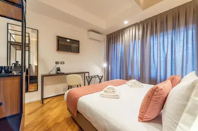 a hotel room with a bed and a desk at Relais Pamphili guest house by Ghor in Rome
