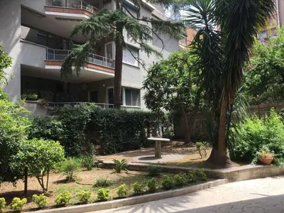 a garden in front of a building with a palm tree at Apartment GLI ARANCI Wohnung by Interhome in Rome
