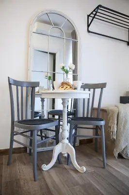 a dining room table with two chairs and a mirror at Maison Coquette in Rome