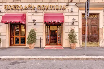 a building with two potted trees in front of a store at Hotel Contilia in Rome