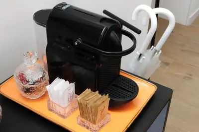 a black coffee maker sitting on a yellow tray at Ricky Bijoux by DomusDimore in Rome