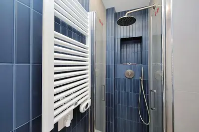 a bathroom with blue tiles and a shower at 4BNB - Marmorata Urban Nest in Rome