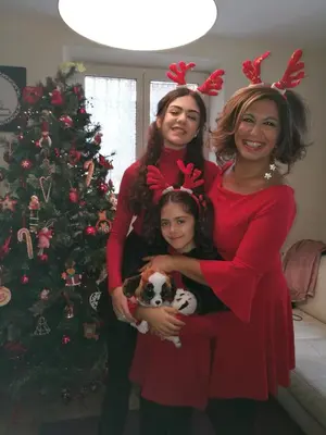 two women and a little girl wearing reindeer hats holding a dog at Alexia Home in Rome