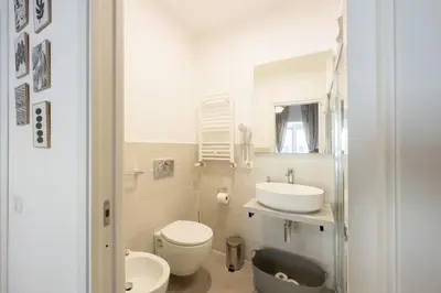a white bathroom with a toilet and a sink at White Ostilia Guesthouse in Rome