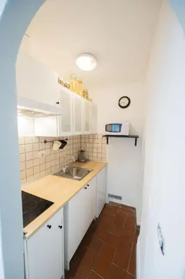 a small kitchen with white cabinets and a sink at Grotto Apartment by Campo de Fiori in Rome