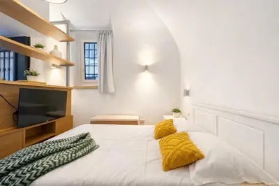a bedroom with a white bed with yellow pillows at Studio Coppelle in Rome