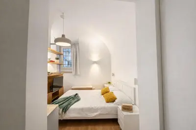 a bedroom with a white bed with yellow pillows at Studio Coppelle in Rome