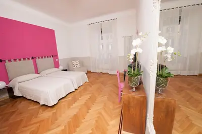 a bedroom with a white bed and a pink wall at Florian Rooms Guest House in Rome