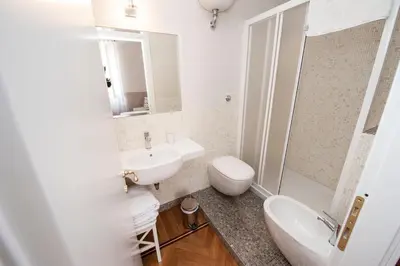 a white bathroom with a sink and a toilet at Florian Rooms Guest House in Rome