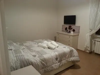 a bedroom with a bed and a dresser and a television at Home Sweet Home in Rome