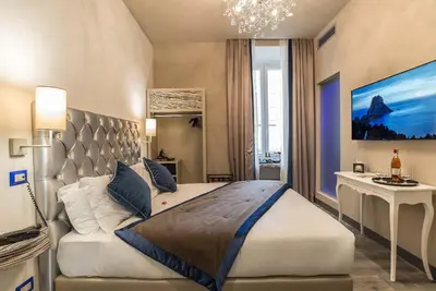 a bedroom with a king sized bed and a desk at Colonna Suite Del Corso in Rome