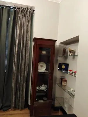a living room with a wooden cabinet and curtains at YourStay@Rome Coliseum in Rome