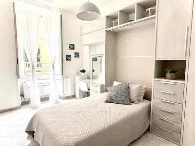 a white bedroom with a bed and a desk at Apartment Roman Haven by Interhome in Rome