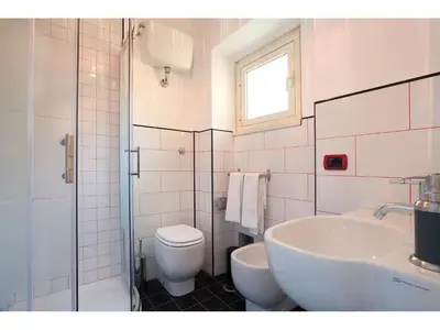 a white bathroom with a toilet and a sink at Alex's Guest House in Rome