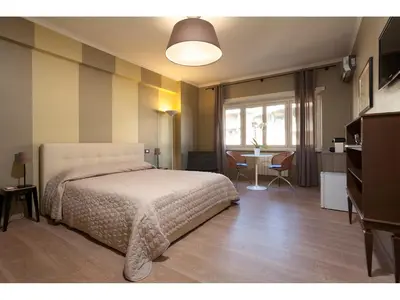 a bedroom with a bed and a desk and a table at Alex's Guest House in Rome