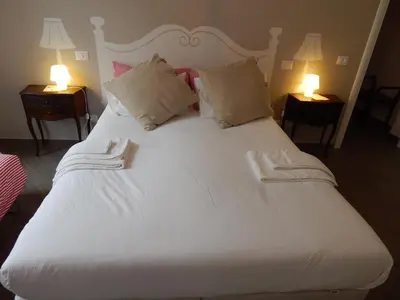 a large white bed with two lamps on two tables at Red Flat In Rome in Rome