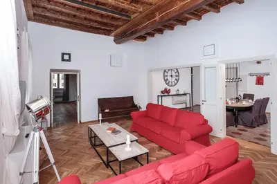a living room with a red couch and a table at Trastevere Wonderful 3BR Apartment in Rome