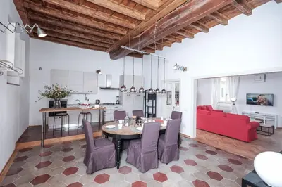 a living room with a table and a red couch at Trastevere Wonderful 3BR Apartment in Rome