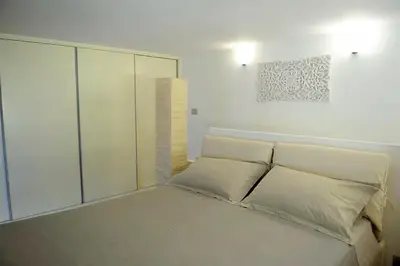 a bed with white pillows and a wall at St. Peter Loft in Rome