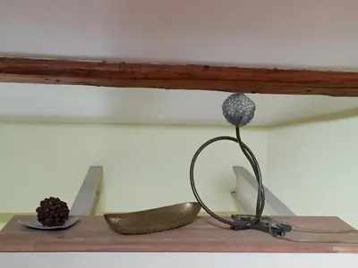 a sculpture of a flower on a shelf with a plate at The Queen in Rome