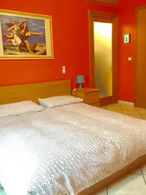 a bedroom with a bed and a painting on the wall at Modì Apartment in Rome