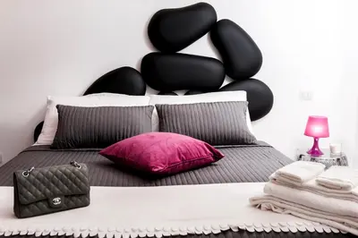 a bedroom with a bed with a black headboard at Two Chic Guesthouse in Rome
