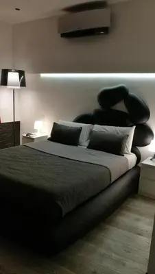 a bedroom with a large bed with black pillows at Two Chic Guesthouse in Rome