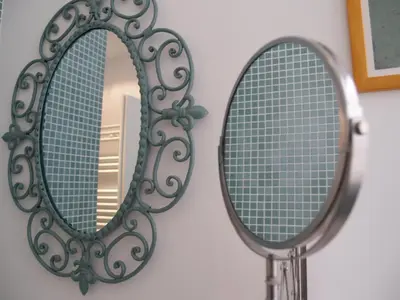a mirror hanging on a wall next to a bathroom at Viadelloca35 in Rome