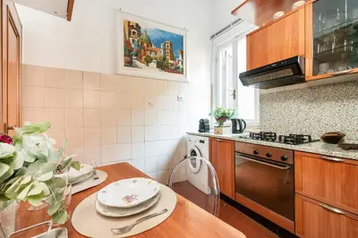 a kitchen with a wooden table with plates on it at Annemary Maison in Rome