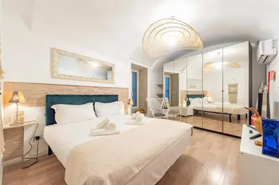 a bedroom with a large white bed and a mirror at BHM Urban House Pigneto in Rome