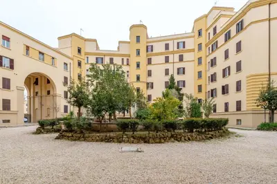 a large building with trees in a courtyard at Residenza Pasolini in Rome