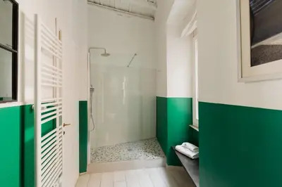 a bathroom with green and white walls and a shower at Campo de Fiori Bright Loft in Rome