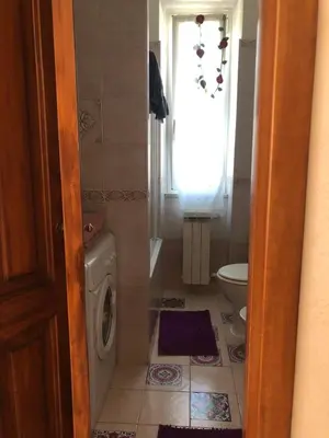 a bathroom with a washing machine and a window at A.B Battistini Short Let's in Rome