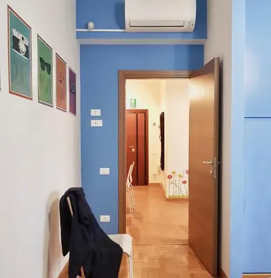 a room with blue walls and a hallway with a chair at Vatican Area Flat in Rome