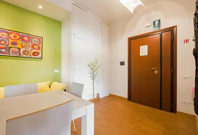 a living room with green walls and a wooden door at Vatican Area Flat in Rome