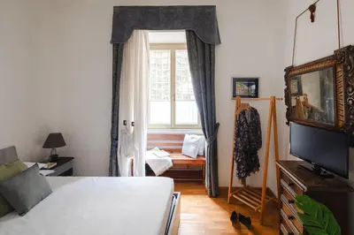 a bedroom with a bed and a window with a couch at B&B Ibiscus in Rome