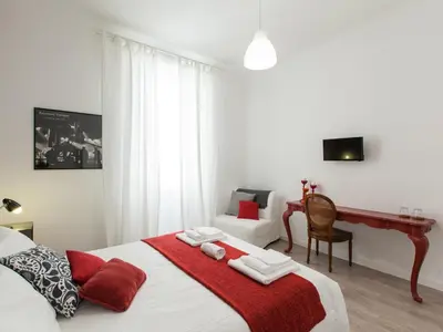 a bedroom with a bed with a red blanket at A+ Bed and Breakfast in Rome