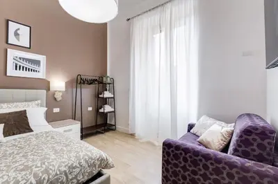 a bedroom with a bed and a purple couch at BDC - The Choice, your 2-Bdr apt in Vatican district in Rome