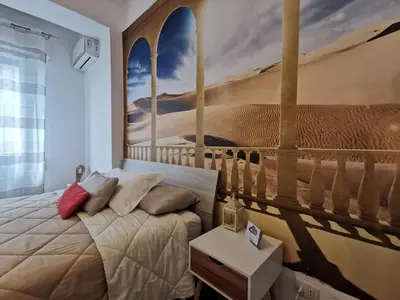 a bedroom with a bed with a painting on the wall at La Finestra Sul Mondo B&B in Rome