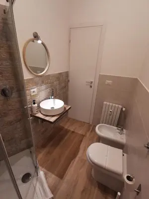 a bathroom with a sink and a toilet and a mirror at La Finestra Sul Mondo B&B in Rome