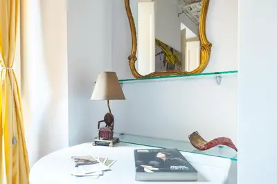 a white table with a lamp and a mirror at Trevi Art Suite in Rome