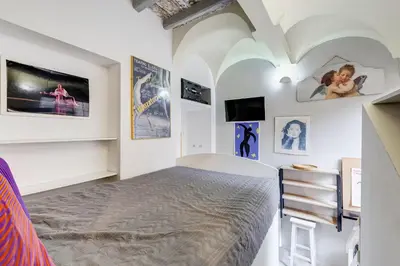 a bedroom with a bed and a tv on the wall at Trevi Art Suite in Rome