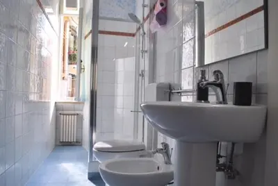 a white bathroom with a sink and a toilet at San Peter's Corner in Rome
