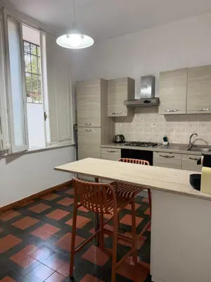 a kitchen with a wooden table and two chairs at St. John Apartment in Rome