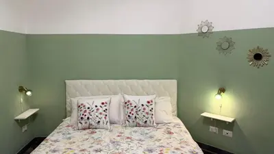 a bedroom with a bed with two lamps and two pillows at St. John Apartment in Rome