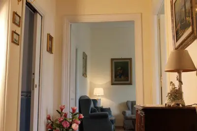 a living room with a blue chair and a mirror at Domus al Palatino in Rome