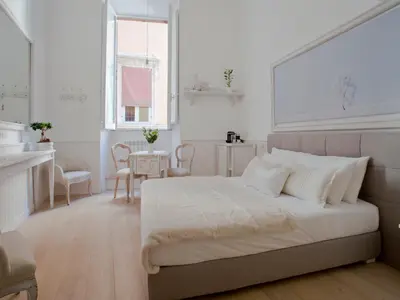 a white bedroom with a bed and a table at Primo Piano Suites in Rome