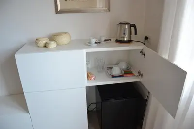 a small white cabinet with a tea kettle on it at Studio Cardello Colosseum in Rome