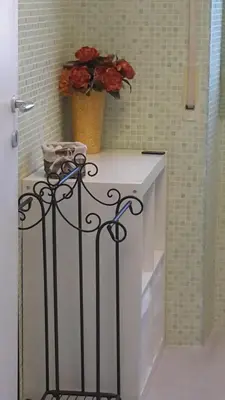 a white counter with a vase of flowers on it at Le Tre Sorelle B&b Garbatella in Rome